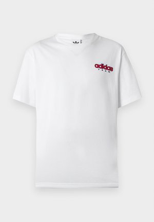 Λευκό βαμβακερό κοντομάνικο T-shirt με κόκκινο λογότυπο adidas και τη λέξη "TEAM" σε μικρότερη γραμματοσειρά στο αριστερό στήθος. Κανονική εφαρμογή.
