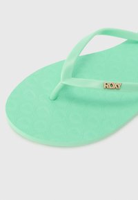 Flip-flop verde mentă cu un suport texturat pentru picior, un bretele subțire și un accent cu logo-ul „ROXY” de culoare aurie pe una dintre bretele.