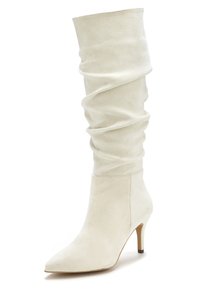 Weißes Wildleder-Knöchelhochschaftstiefel mit weicher, geraffter Textur, spitzem Schuhkopf und schlankem Absatz. Glatte, unverzierte Außenseite.