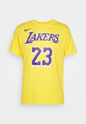 Yellow short-sleeve t-shirt featuring "LAKERS" in purple and "23" in white with purple accents. Made of cotton with a round neck design.
