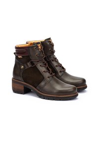 Botas cortas de cuero marrón con un panel de ante, puntera redonda, cordones en la parte delantera y un tacón texturizado. Presenta un forro en contraste en tono beige y detalles de hardware.