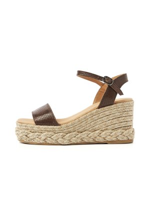 Brown leather ankle-strap wedge sandal with braided jute platform sole and buckle closure, shown from the side on a white background.