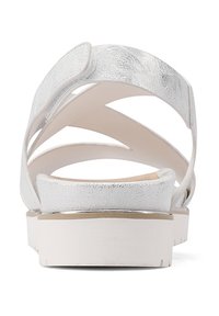 Sandal in metallo argento con più cinturini incrociati, suola ammortizzata, suola bianca e tacco piccolo. Texture liscia e design minimalista.