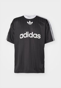 Černé tričko Adidas s krátkými rukávy, s bílým logem na hrudi a třemi bílými pruhy na každém rameni. Hladká textilie.