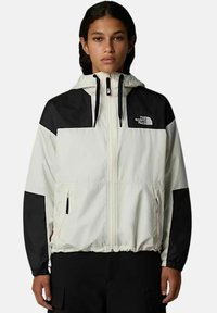 Lekki wiatrówka z białym korpusem, czarnymi rękawami, regulowanym kapturem, kieszeniami na zamek oraz elastycznymi mankietami.