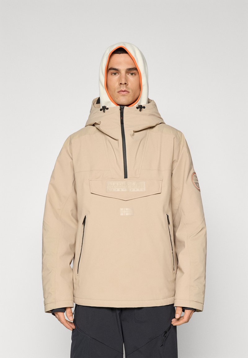 Veste imperméable beige avec un col montant, capuche ajustable avec doublure orange contrastante, logo sur la poitrine et poches latérales zippées.