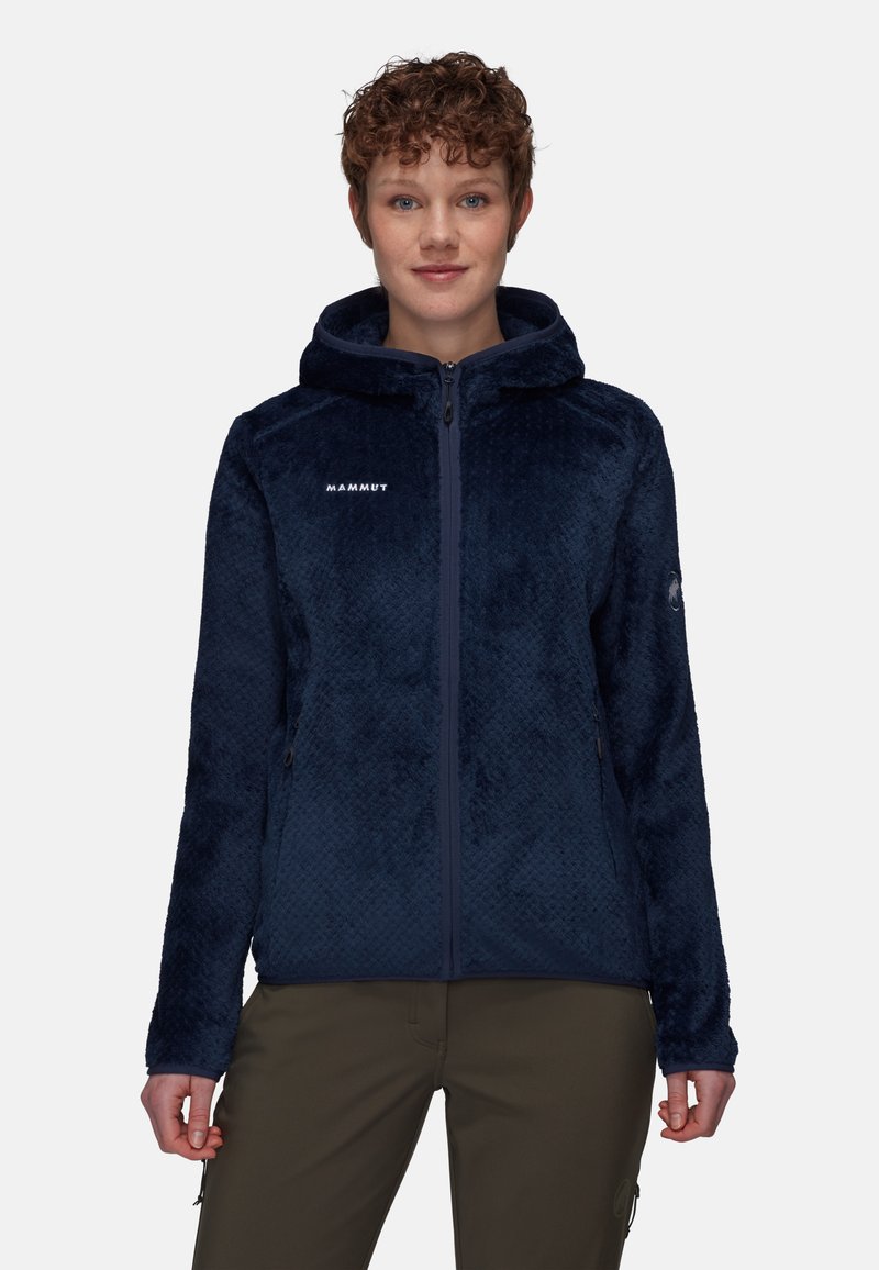 Marinblå fleecejacka med ett strukturerat mönster, dragkedja och huva. Har en logotyp på bröstet och sidofickor. Mjuk material.