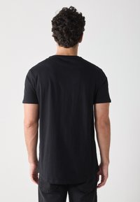 T-shirt noir en coton à manches courtes, col rond et coupe droite. Le matériau semble doux avec une texture lisse.