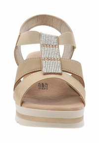 Sandali beige con tre fasce larghe, una suola testurizzata e un accento frontale con strass. Sole leggero con un leggero tacco.