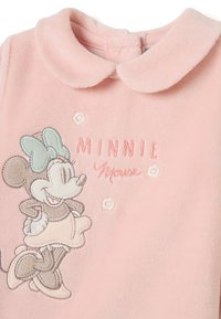 Prenda de forro polar rosa con un diseño bordado de Minnie Mouse, acentuado con un lazo y detalles florales. Cuello con solapa y cierre a presión.
