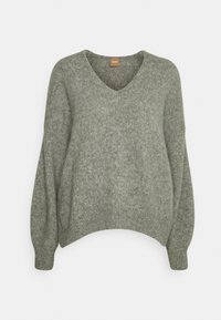 Grüner Strickpullover mit V-Ausschnitt, weiten Ärmeln, abgeschnittenem Design und weicher Textur. Abgeschlossen mit geripptem Saum und Bündchen für zusätzliche Details.