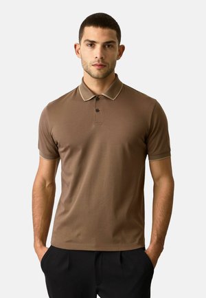 Camisa polo marrón de tela suave con un cuello y puños en un ligero beige que contrasta. Cierre de tres botones, ajuste elegante y mínima imagen de marca.