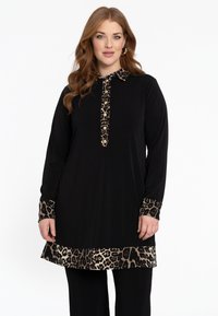 Zwarte tuniek met een kraag en manchetten van luipaardprint, voorzien van een knoopsluiting, lange mouwen en een luipaardprint onderrand. Zacht stoftextuur.