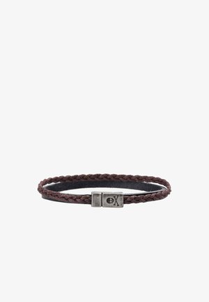 Pulsera de cuero trenzado marrón con un cierre de plata que presenta un pequeño diseño de calavera y huesos cruzados.