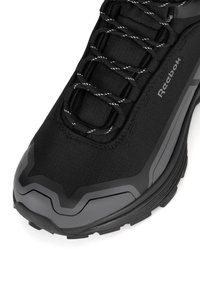 Juodas sportinis batelis su tekstūruota paviršiumi, kontrastinėmis pilkomis detalėmis ir atspindinčiomis raištelėmis. Apima guminį pado dizainą su tvirtu raštu.