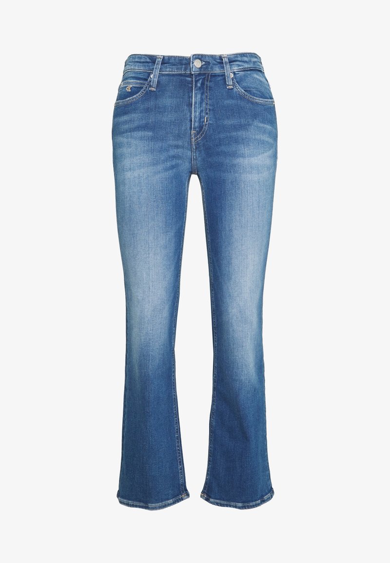 Jeans de mezclilla azul de corte acampanado con cintura de altura media, que cuentan con diseño de cinco bolsillos y un ligero desgastado en la parte frontal para un aspecto usado.