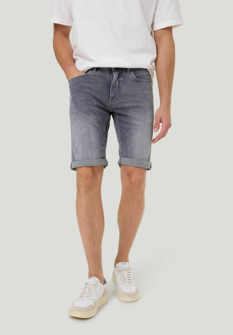 Grijze denimshorts met een casual opgerolde zoom, voorzien van een klassiek vijf-pocket ontwerp en een versleten look, gedragen met witte sneakers.