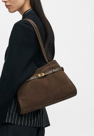 Brązowa torebka zamszowa o wyraźnej, usztywnionej formie, z zapięciem w kolorze złotym i skórzanym paskiem, prezentowana na neutralnym tle.