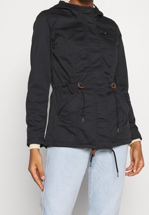 Černá kapucí bunda se zipem vpředu, nastavitelnými šňůrkami v pase a bočními kapsami. Má prošívanou texturu a elastické manžety.