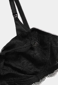 Sort blonder-bh med blomsterprint, justerbare stropper og en tekstureret overflade. Inkluderer lukkemekanisme for sikker pasform.