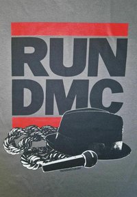 Šedé tričko s výrazným černým textem "RUN DMC", černým kloboukem fedora, mikrofonem a grafikou zkrouceného řetězu v bílé a černé barvě.