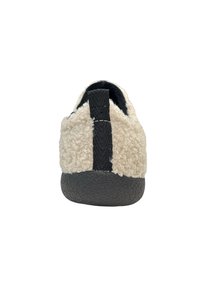 Lichtbeige slipper met een gestructureerde, donzige bovenkant en een donkergrijze rubberen zool. Voorzien van een zwarte stoffen lus aan de achterkant.
