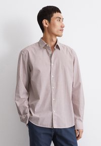 Camicia a maniche lunghe con un motivo a righe rosse e bianche, colletto a camicia e tessuto morbido. Bottoni semplici e vestibilità comoda.