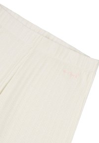 I pantaloni lounge a coste color beige chiaro presentano una texture morbida e una cintura elastica con un piccolo dettaglio del logo rosa sul lato.
