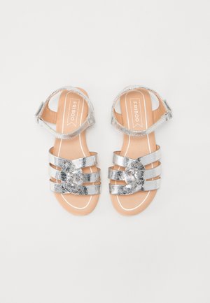 Sandalias metálicas plateadas para niños con tres tiras delanteras, tiras para el tobillo con hebillas y plantillas beige con la etiqueta "FRIBOO".