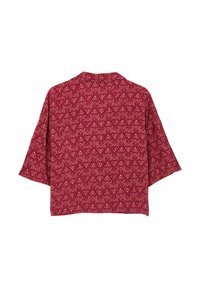 Kimono rosso a motivi con maniche lunghe fino al gomito, caratterizzato da un motivo floreale ripetitivo in una tonalità più chiara. Realizzato in un tessuto testurizzato.
