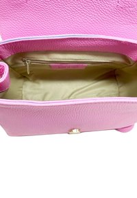 Rosa läderhandväska med en pebblad textur, guldfärgad hårdvara och beige tygfoder. Inuti finns en ficka med dragkedja.