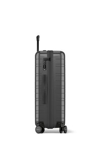 Valise rigide de couleur gris foncé, avec un design à rainures verticales, une poignée rétractable, une serrure à combinaison et quatre roues multidirectionnelles.