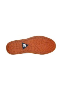 Suela de zapato de goma en color naranja con un patrón texturizado en zigzag, que presenta un logo triangular negro en el centro. Diseño plano y flexible.