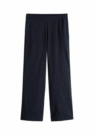 Tmavě modré široké kalhoty s texturovanou látkou a elastickým pasem, zobrazené na bílém pozadí.