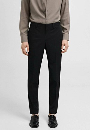 Black tailored pants with a straight leg design, made of smooth fabric, paired with a beige button-up shirt and black loafers.
