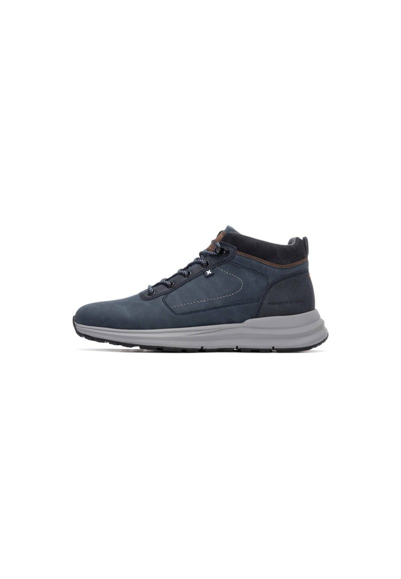 Zapatillas de media caña azul oscuro con una textura suave, suela gris y acentos marrones. Presentan un diseño de cordones y un collar acolchado para mayor comodidad.