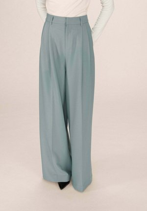 Pantalons larges en tissu doux de couleur bleu clair avec une texture lisse, présentant des plis bien taillés et une taille ajustée.