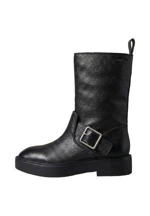 Bota negra de cuero hasta mitad de la pantorrilla con acabado texturizado, correa ancha y hebilla plateada en el lateral, suela gruesa y lengüeta en la parte trasera.
