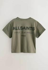 Oliwkowa krótka koszulka wykonana z miękkiej bawełny. Na przodzie czarny napis "ALLSAINTS" oraz inne znaki, z krótkimi rękawami i zaokrąglonym dekoltem.