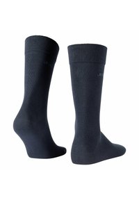 Medias largas de color azul oscuro hasta la rodilla, con un ribete en la parte superior, textura suave y un talón ligeramente reforzado. Branding minimalista mostrado en el lateral.