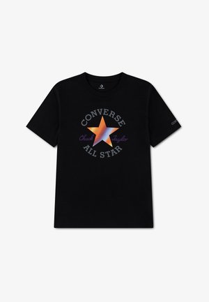 Sort T-shirt med korte ærmer med en stor gradient orange og blå stjerne i midten, omgivet af teksten "Converse All Star Chuck Taylor."