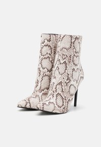 Botas de tornozelo com padrão de pele de cobra em tons de bege e castanho; bico pontiagudo; salto alto em stiletto; textura suave com acabamento brilhante.