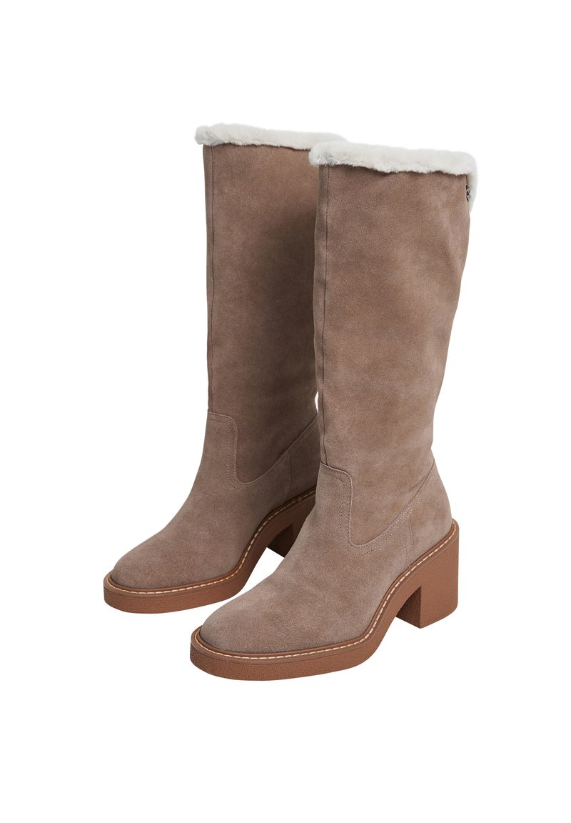 Ein Paar braune Wildlederstiefel in mittlerer Schafthöhe mit weißem Kunstfellfutter an der Oberseite und massiven braunen Blockabsätzen auf einem weißen Hintergrund.