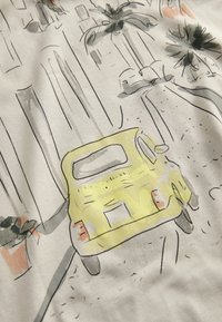 Gelbes Vintage-Auto, auf Stoff skizziert, mit schwarzen Umrisslinien und einem Aquarell-Hintergrund, der Palmen und Straßendetails zeigt.
