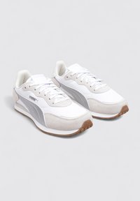 Zapatillas deportivas blancas con detalles en gris, materiales de ante y malla, punta redonda, cierre con cordones y suela de goma texturizada.