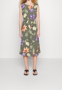 Sukienka w kwiatowy print z krótkimi rękawami, na oliwkowym tle, zdobiona pomarańczowymi, fioletowymi i białymi kwiatami; talia podkreślona paskiem; rozkloszowany dół.