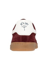 Baskets en suède bourgogne avec un accent en cuir blanc au talon comportant le logo "JOOP!" et une semelle en gomme. Design simple et moderne.