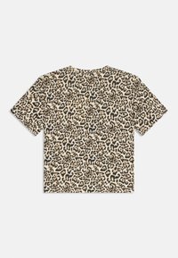 Šortsleeve leopardu izdrukas t-krekls bēšā krāsā ar melnām un brūnām plankumainām. Izgatavots no kokvilnas, ar brīvu piegriezumu un apaļu izgriezumu.