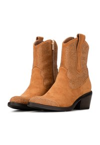 Botines de ante en color marrón con acentos decorativos de remaches, cremalleras laterales y un tacón moderado; cuentan con un diseño ondulado en el cañón.
