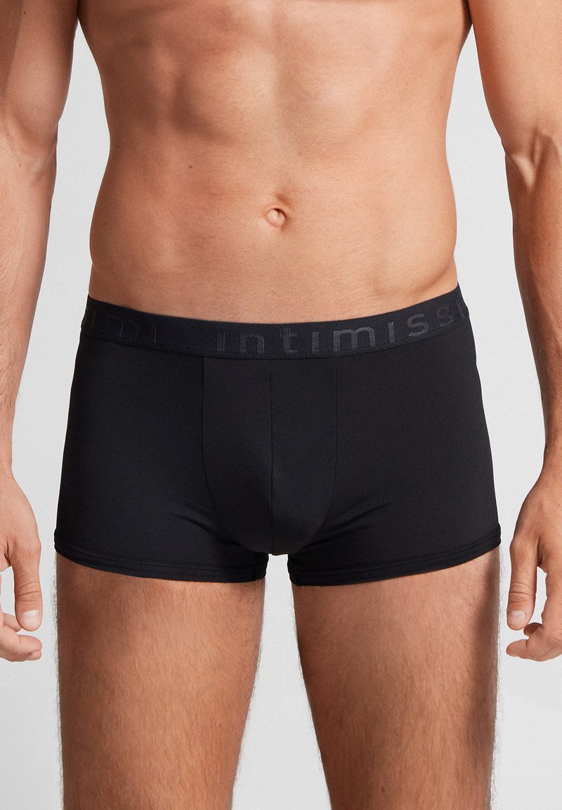 Svarta boxershorts gjorda av ett mjukt, elastiskt tyg. Har en bred elastisk midja med varumärket i mörkgrått.